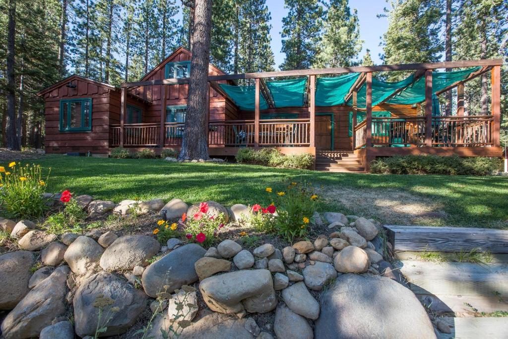 eine Blockhütte im Wald mit einem Steingarten in der Unterkunft Ward Creek Retreat - Cozy Old Tahoe Cabin w Short Drive to Ski Resorts Pet Friendly in Tahoe City