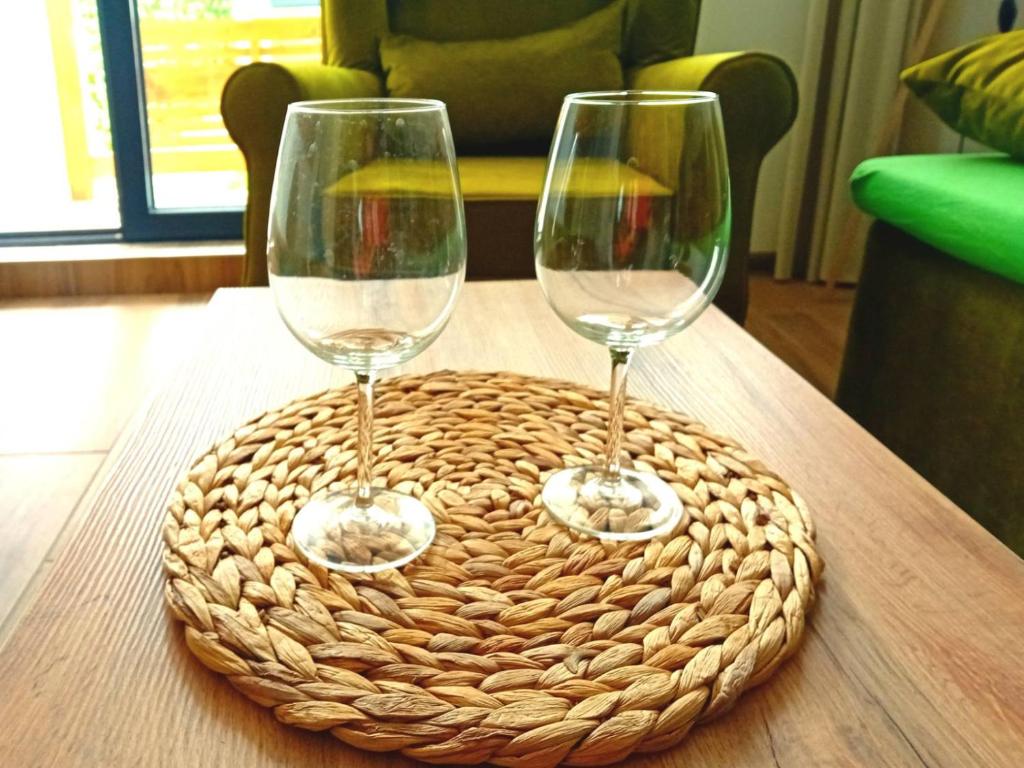 two wine glasses sitting on a basket on a table at Diego - Ravna planina in Pale