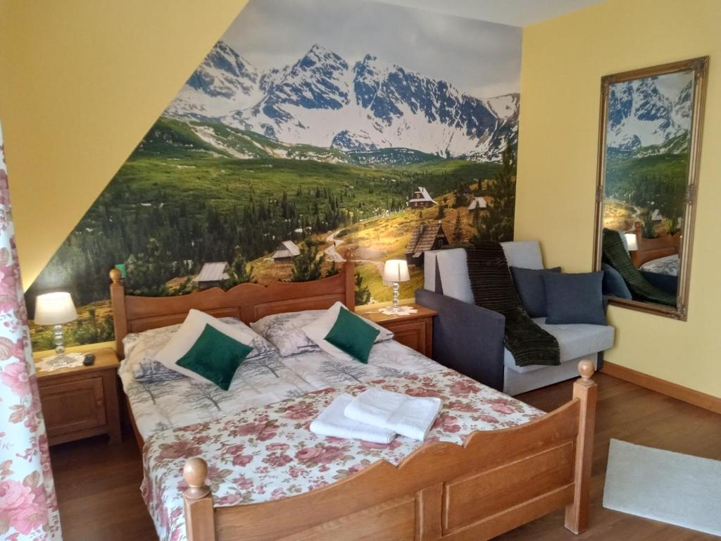 a bedroom with a bed with a mountain mural on the wall at Bębenkowie in Białka Tatrzańska
