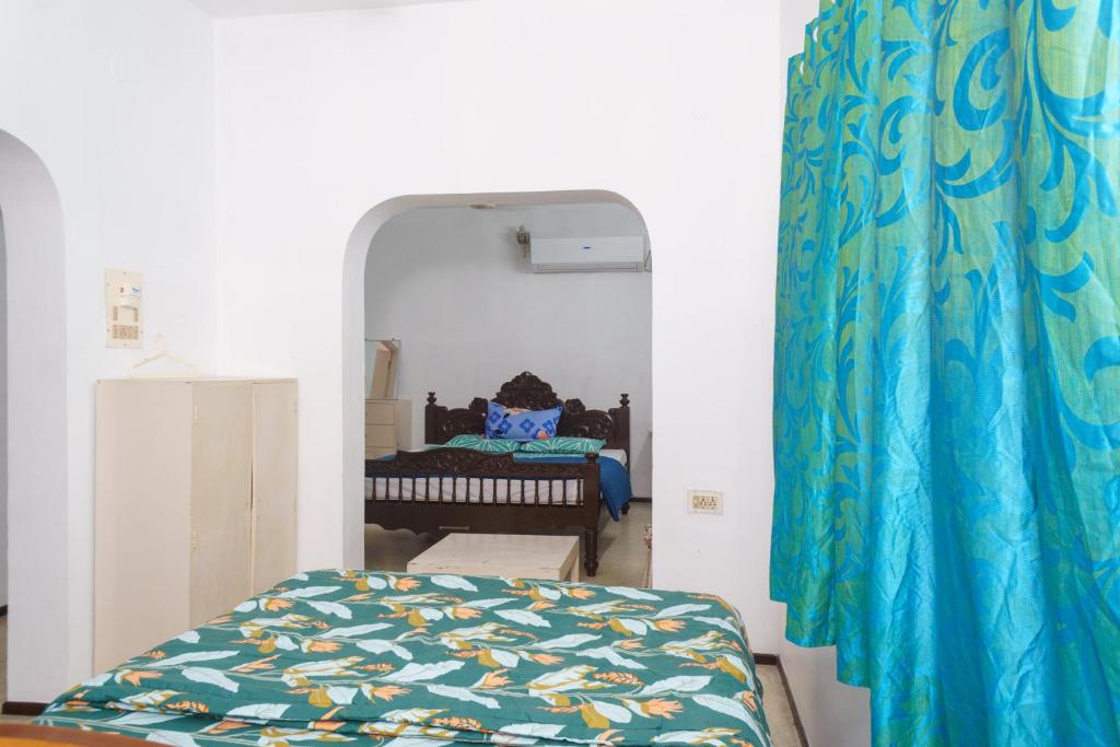 a bedroom with a bed and a mirror at Kadal Homestay in Puducherry