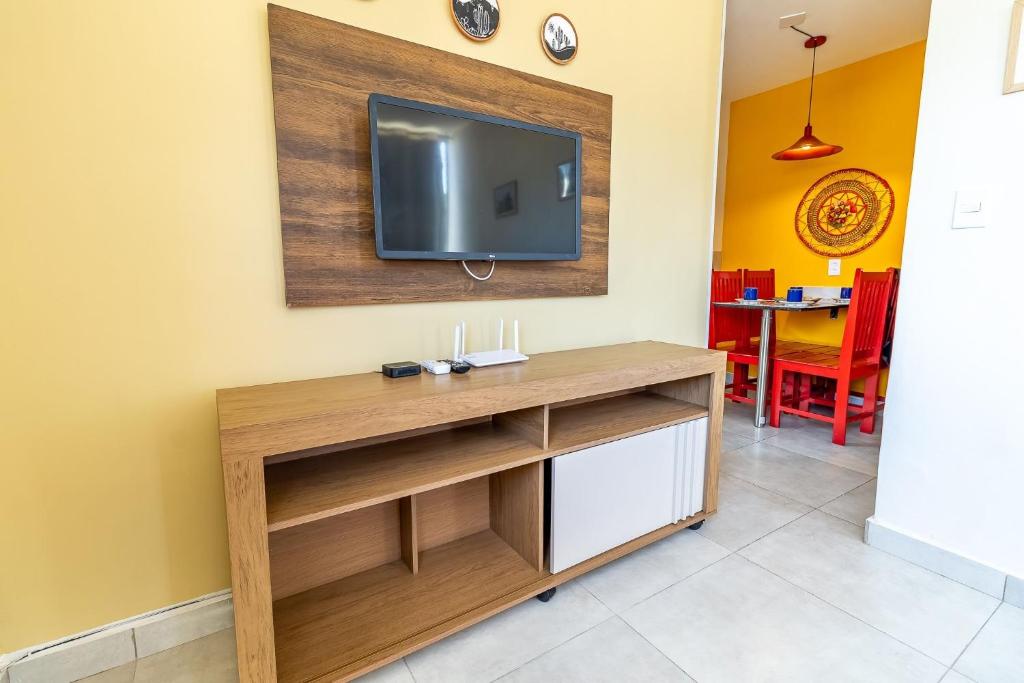 ein Wohnzimmer mit einem TV an der Wand in der Unterkunft Encanto do Francês (4 minutos, a pé, da Praia) in Praia do Frances