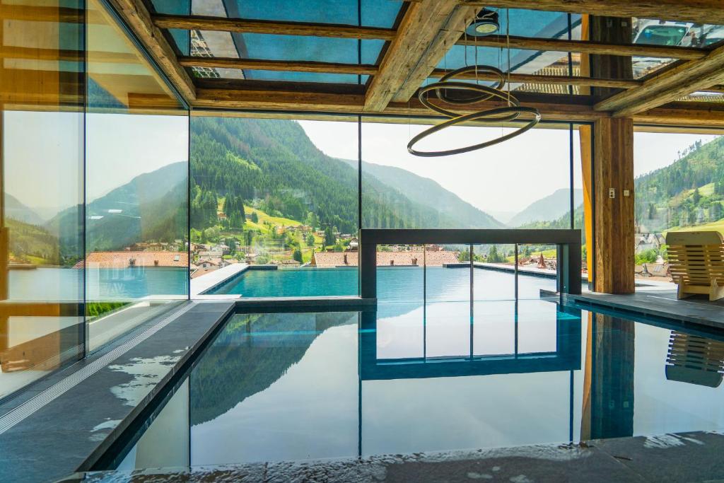 a swimming pool with a view of a mountain at Resort Dolce Casa - Family & Spa Hotel in Moena
