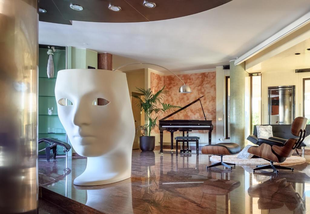 a living room with a piano and a largeumedumed head at La Gigasuite - Design Villa at Sea with Spa & Pool in Taranto