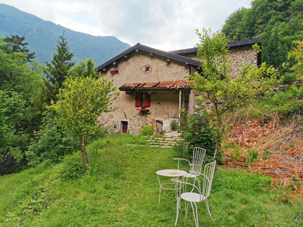 uma mesa e cadeiras em frente a uma casa em B&B Il Mulino alla Busa em Vallarsa