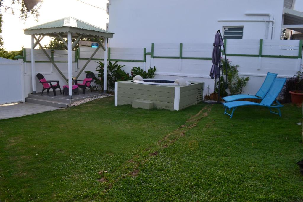 einen Hinterhof mit einem Whirlpool und einem Pavillon in der Unterkunft Les Colibris in Sainte-Anne