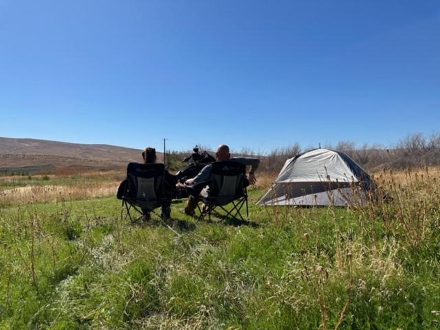 a group of three people sitting in chairs next to a tent at Infidel Acres Motorcycle camping in Naches
