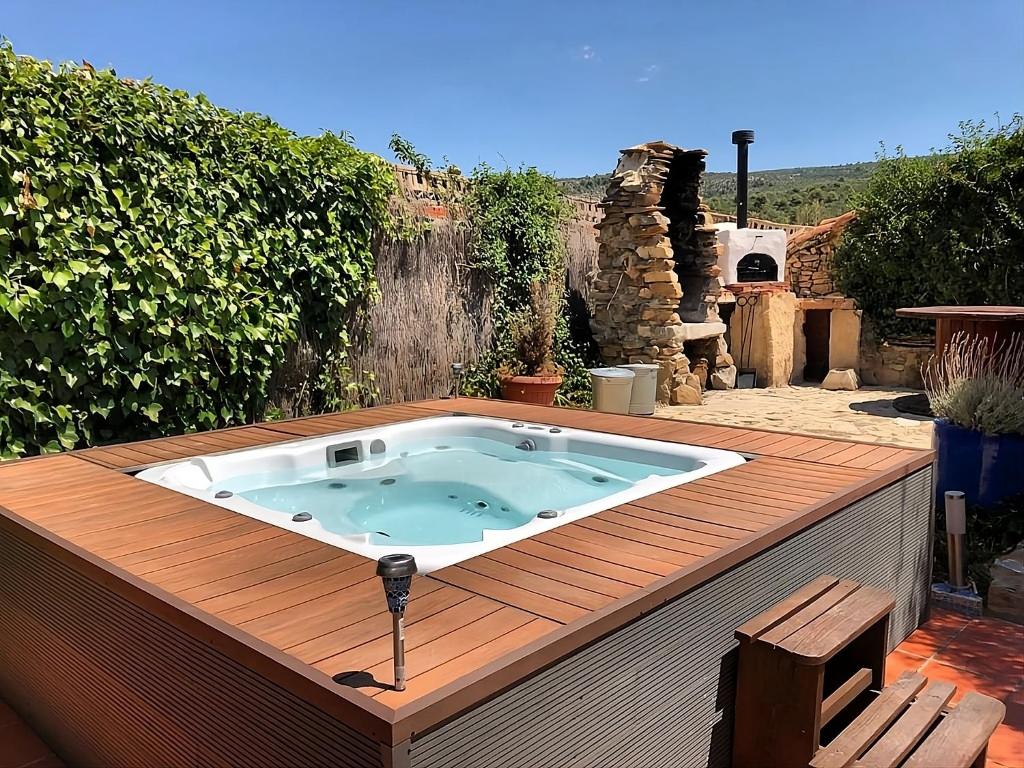 un bain à remous installé au-dessus d'une terrasse en bois dans l'établissement El Cau dels Somnis, à La Cuevarruz