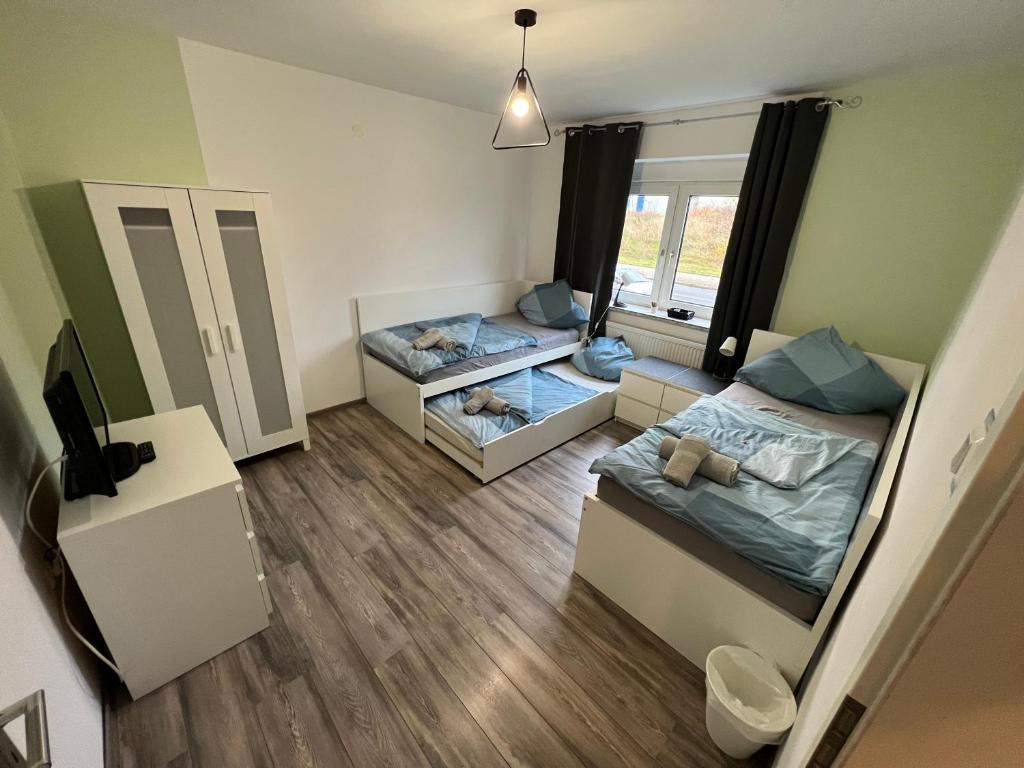 um pequeno quarto com 2 camas e um sofá em Pluto em Gelsenkirchen