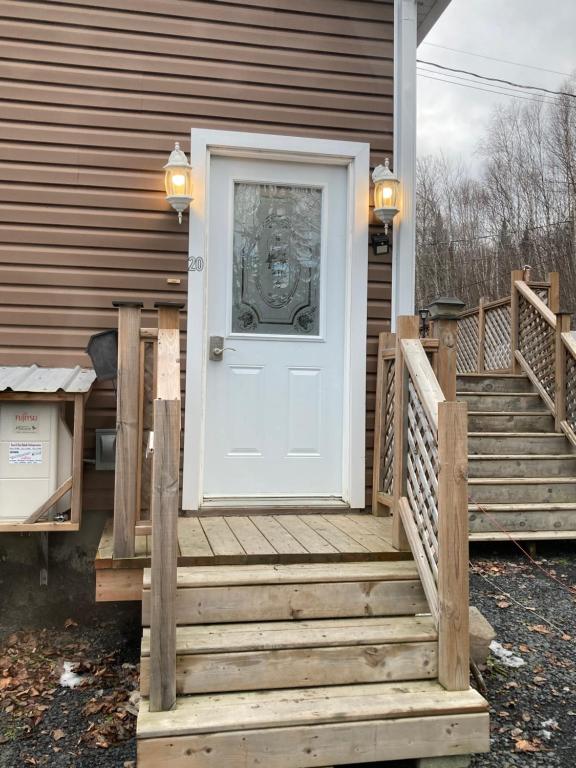 a white door on a house with stairs at Executive Guest Suite in Edmundston