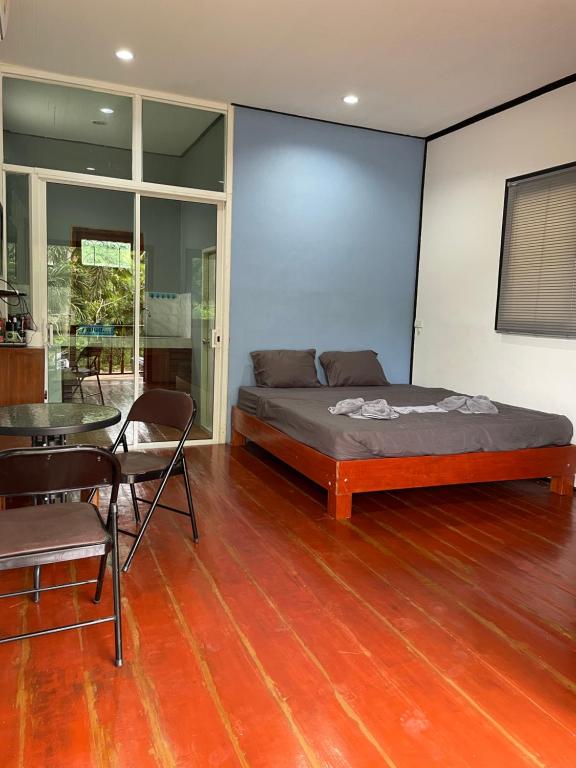 een slaapkamer met een bed en een tafel. bij Nuree Villa & Bungalow in Phra Ae beach