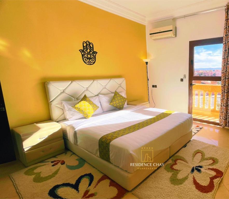 een slaapkamer met een groot bed en een raam bij Residence Chay - Appartement de luxe in Ouarzazate