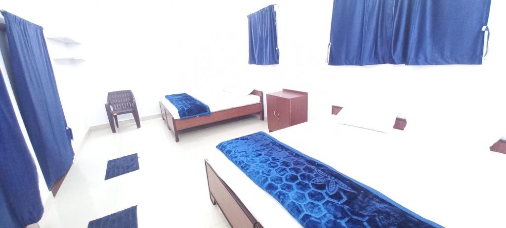 バラナシにあるMahadev Home Stayのベッドと椅子付きの小さな部屋です。