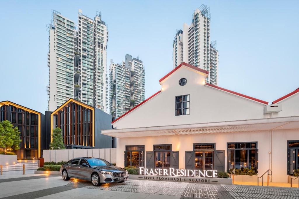 un coche aparcado frente a un edificio con edificios altos en Fraser Residence River Promenade, Singapore en Singapur