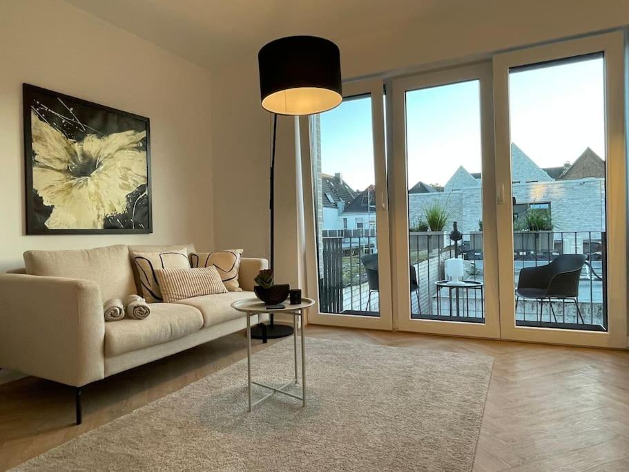 een woonkamer met een bank en een tafel bij Stilvolles Ferinen-Apartment im Herzen von Xanten in Xanten