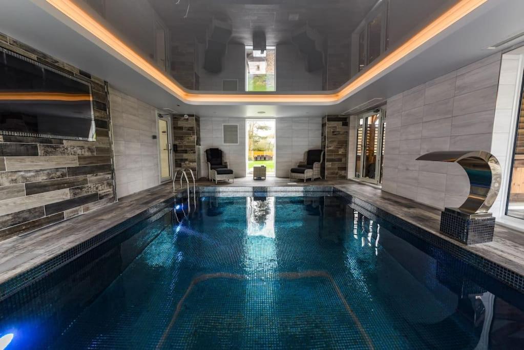 a swimming pool in a house with a swimming pool at Jaw Dropping House with Private Indoor Pool and Hot Tub in Peover Superior