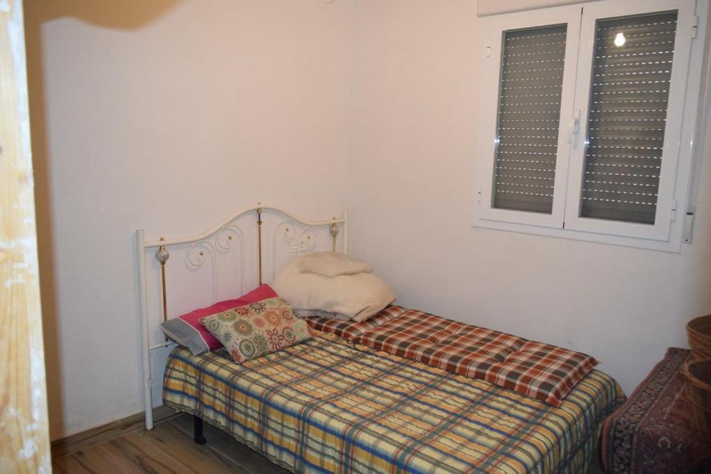 ein kleines Bett in einem Zimmer mit Fenster in der Unterkunft The white house 