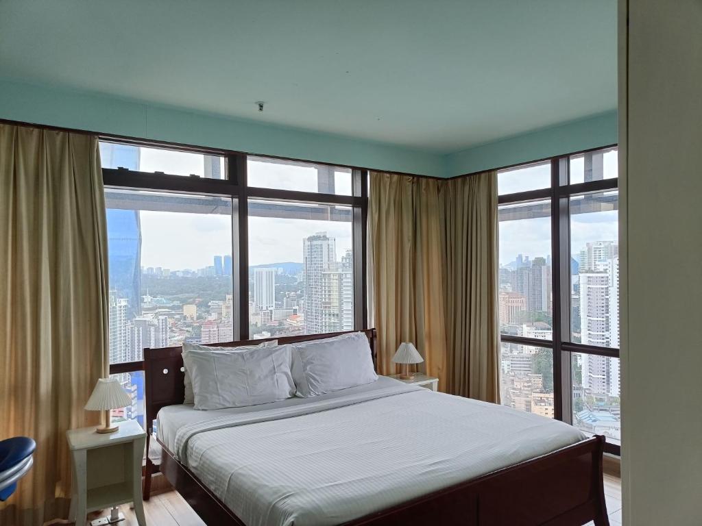 een slaapkamer met een bed en een groot raam bij Times Square Apartment By Skyline in Kuala Lumpur