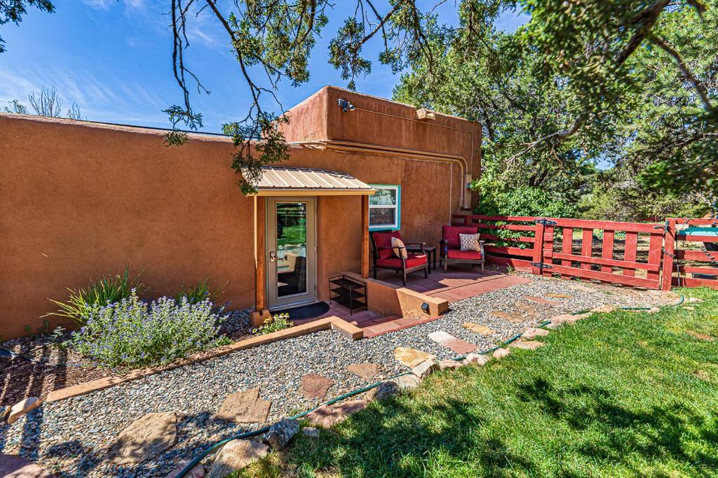 a house with a red fence and a patio at Pet Friendly Piñon Heaven in Santa Fe