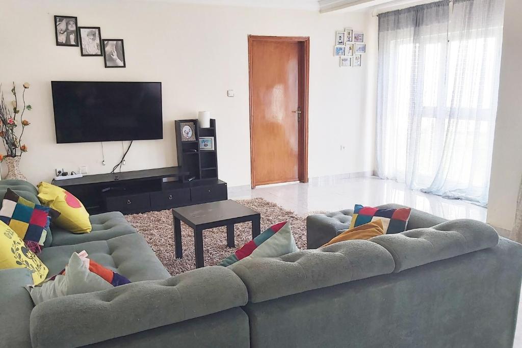 sala de estar con sofá y TV de pantalla plana en Attractive 1 BR House in Bole Atlas, en Addis Ababa