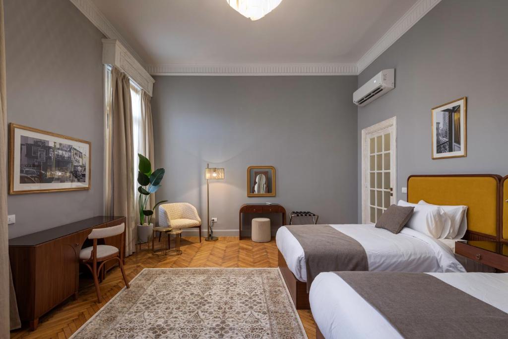 um quarto de hotel com duas camas e uma secretária em Lemon Spaces VINTAGE- Downtown em Cairo