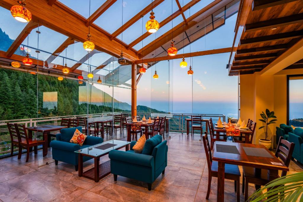 un restaurante con mesas y sillas y vistas al océano en Alt Life Luxe - Uppper Bhagsu Mcleodganj, en McLeod Ganj