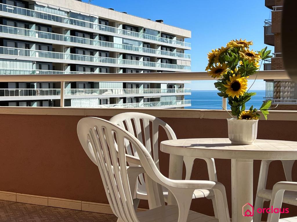 een tafel en stoelen op een balkon met een cruiseschip bij Bella Terraza frontal al Mar in Oropesa del Mar