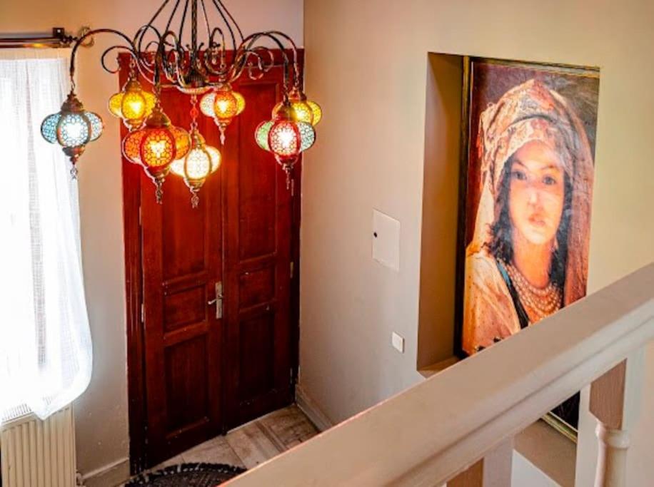 a hallway with a painting of a woman next to a door at Private mansion in kumkapı in Istanbul