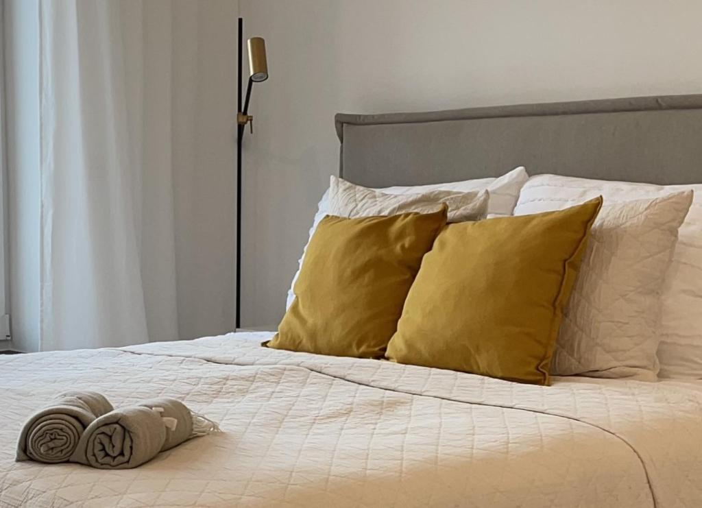 Bett mit weißer Bettwäsche und gelben Kissen in der Unterkunft Stilvolles Zimmer mit Bad im historischen Stadtkern von Xanten in Xanten