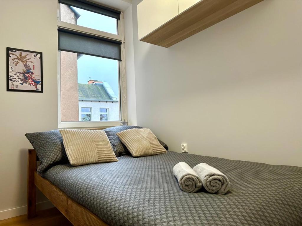 a bedroom with a bed with pillows and a window at MMRent Tiger Room in Gdańsk