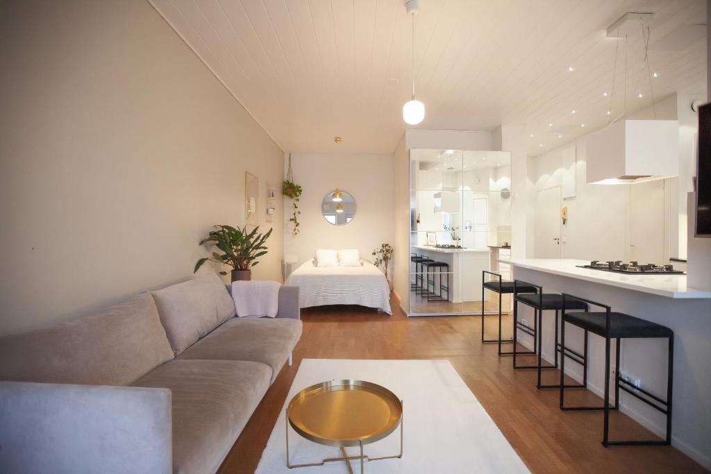 a living room and kitchen with a couch and a table at Luxury Nordic Loft with Great Kitchen and Location in Helsinki