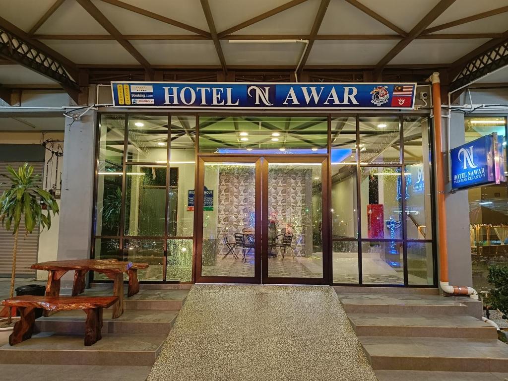 a hotel entrance with a bench in front of it at Hotel Nawar in Pasir Mas