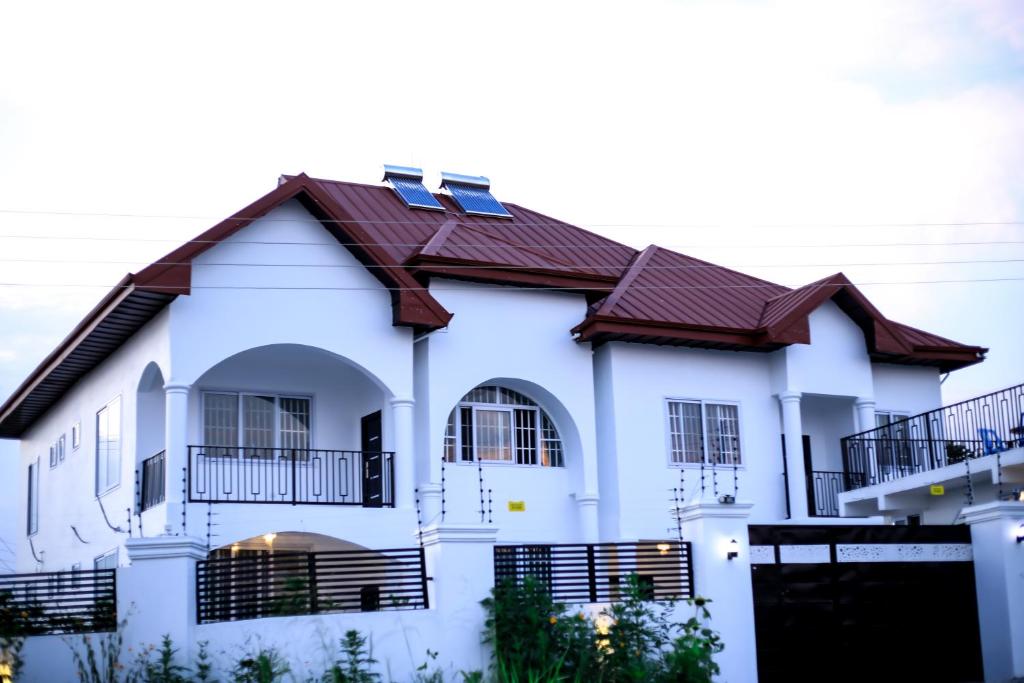 a white house with a brown roof at MILYREX VILLA 
