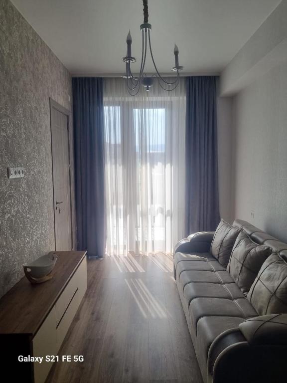 sala de estar con sofá y ventana grande en Apartment, en Tiflis