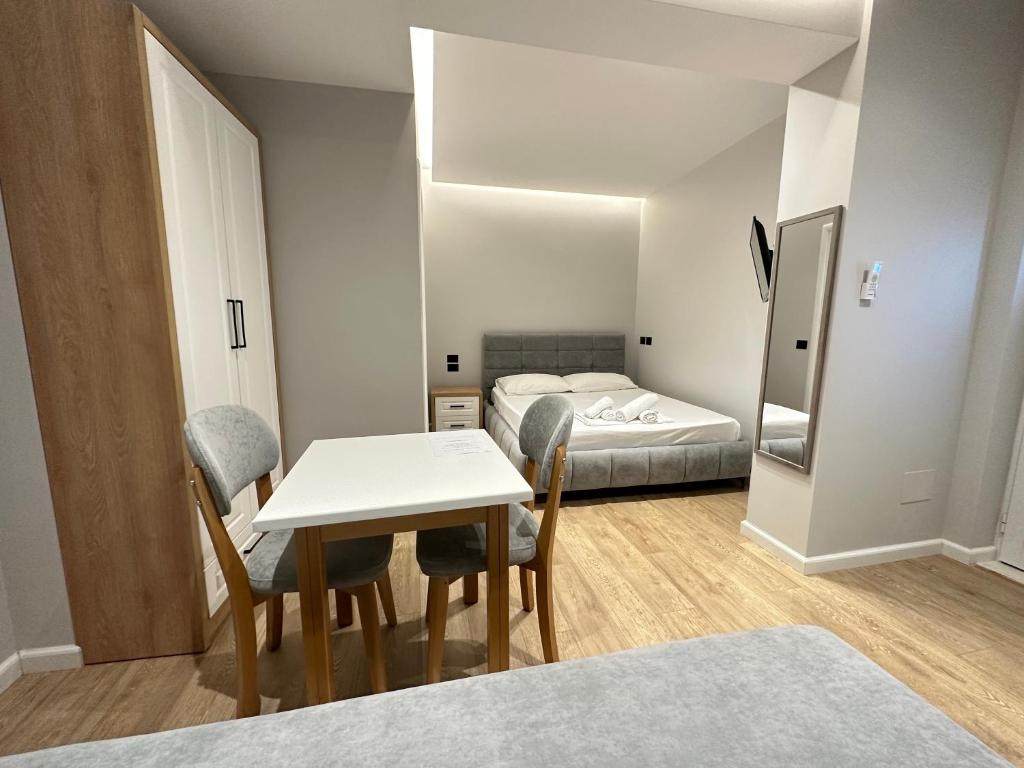 ein kleines Zimmer mit einem Tisch und einem Bett in der Unterkunft Maison Apartments in Vlorë