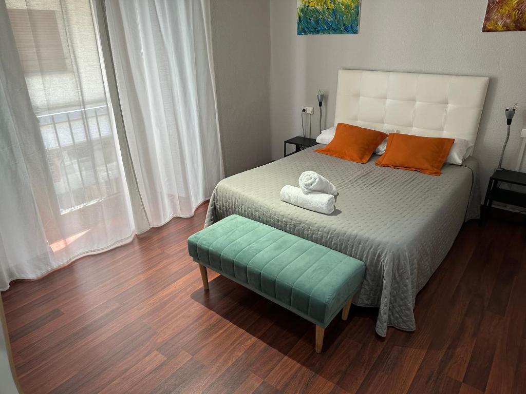 1 dormitorio con 1 cama con reposapiés verde en Hostal ARS en Puigcerdà