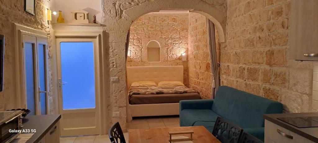 オストゥーニにあるLa Casucciaのレンガの壁にベッドが備わる小さな客室です。