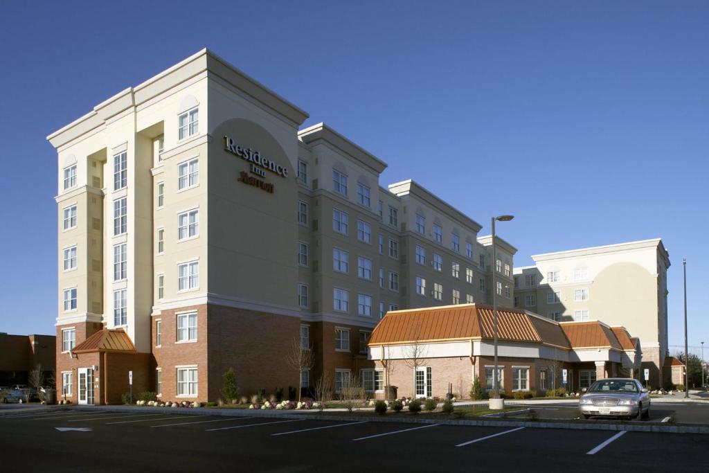 a building with a car parked in front of it at Residence Inn East Rutherford Meadowlands in East Rutherford