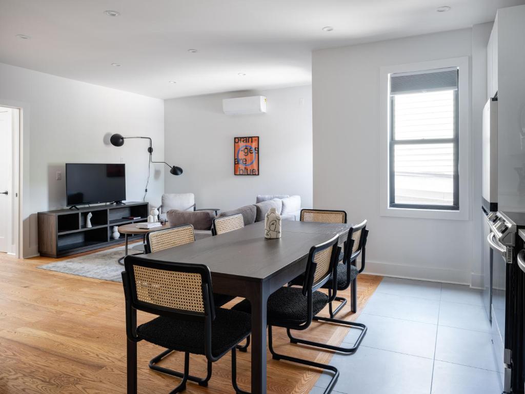 布魯克林的住宿－Modern Three Bedroom Brooklyn Condo-Hotel，用餐室以及带桌椅的起居室。