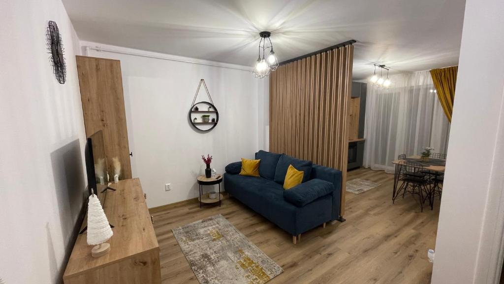 a living room with a blue couch and a table at Alexia Flat in Sibiu