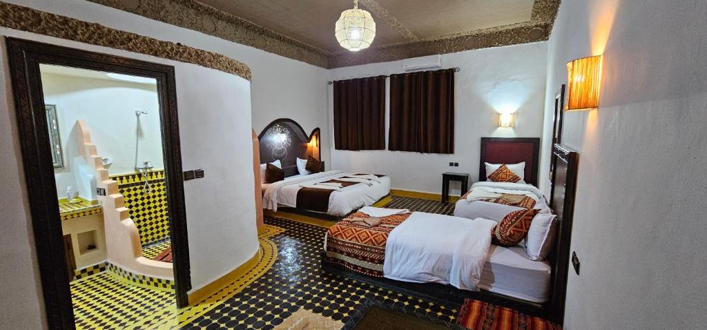 a hotel room with two beds and a mirror at Traditional Riad Merzouga Dunes in Merzouga