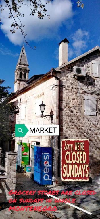 an old building with signs on the side of it at Apartment Mediterraneo Blue Sky in Perast