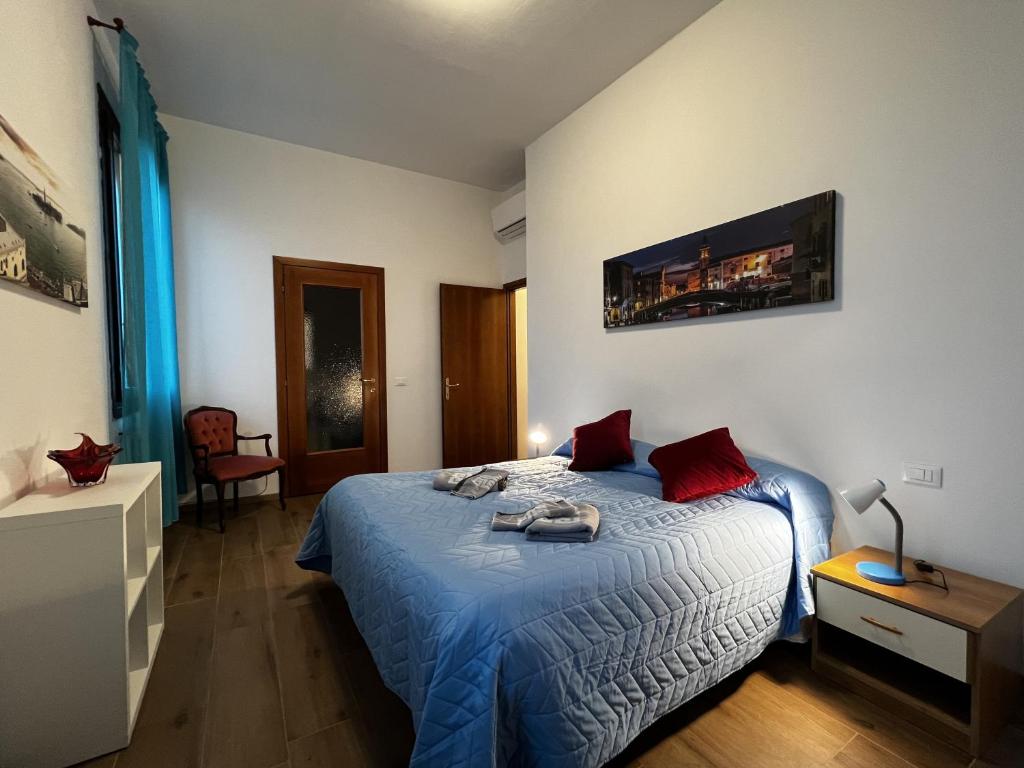 a bedroom with a bed with blue sheets and red pillows at TINTORETTO 1 CON TERRAZZA SOPRA IL TETTO, 3 bagni, 3 grandi camere da letto, SUPER NUOVO in Venice
