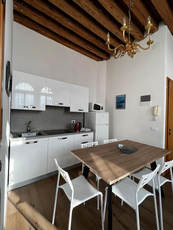 a kitchen with a wooden table and white cabinets at TINTORETTO 1 CON TERRAZZA SOPRA IL TETTO, 3 bagni, 3 grandi camere da letto, SUPER NUOVO in Venice