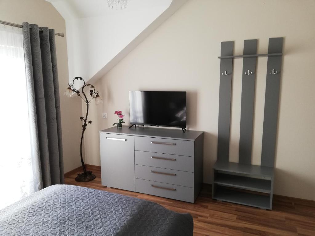 una camera con letto e TV su un comò di Apartament Olszynowy Gaj 4 a Cracovia