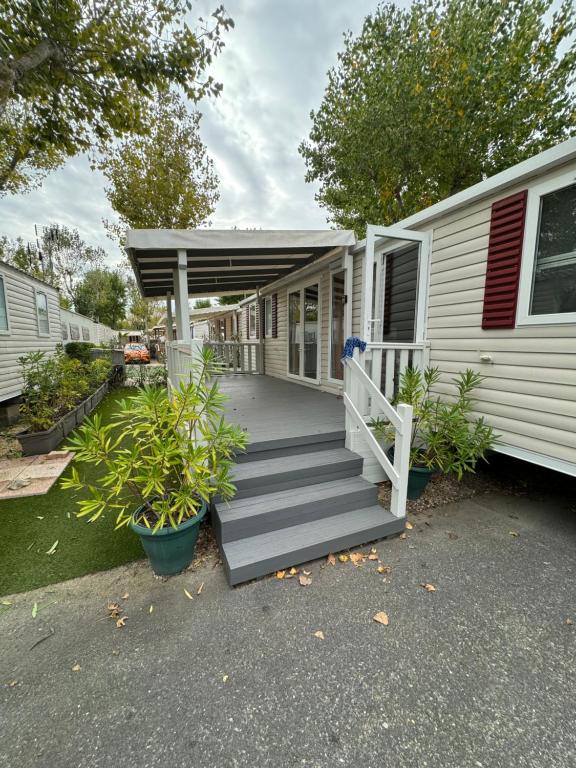 a home with a porch and stairs to a house at MH TIKE - 4p - Les Sables du Midi - Valras in Valras-Plage