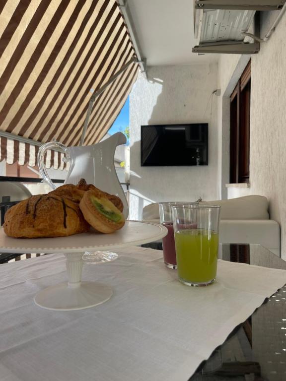 a table with a plate of bread and a glass of orange juice at CASA al mare MATTIA in Lido di Fermo