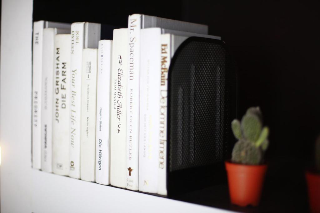 a row of books on a shelf with a plant at Blu Monkey Hub and Hotel Phuket Town- Free All Day Coworking space in Phuket Town