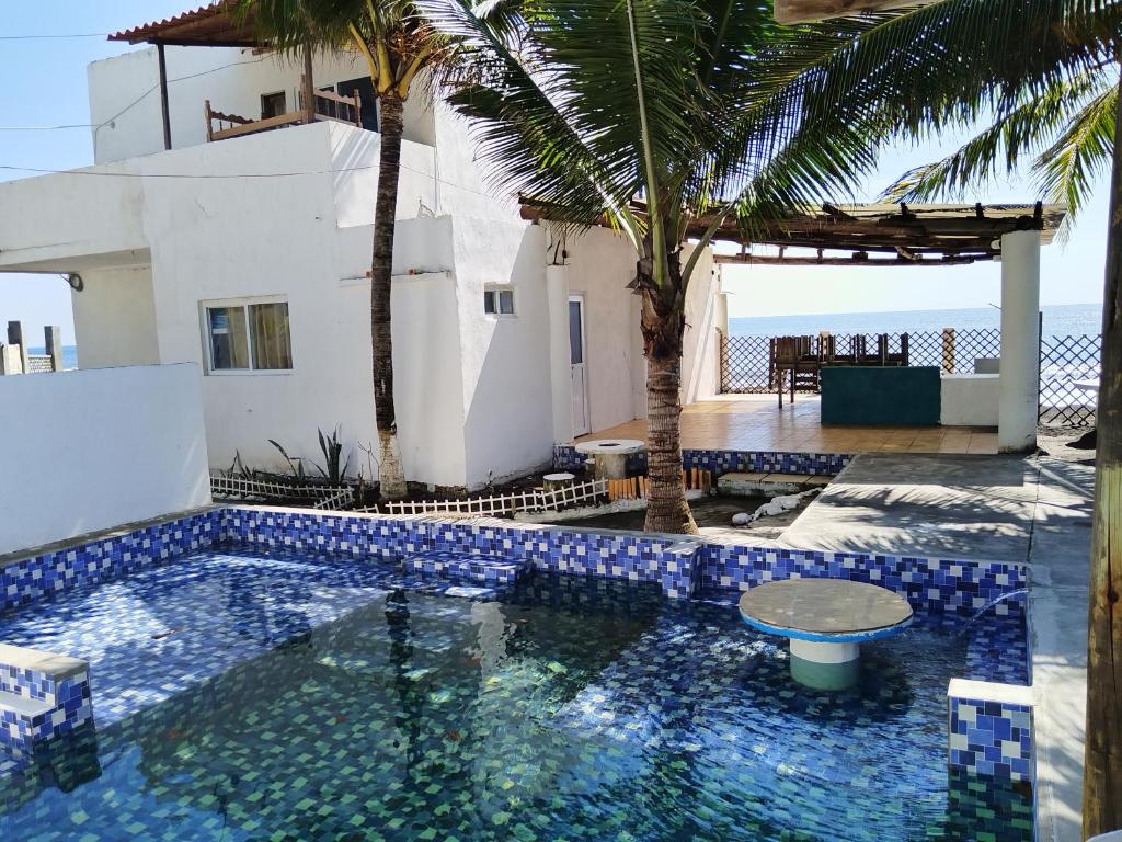 a swimming pool in front of a house with the ocean at Villas Higuer in Escuintla