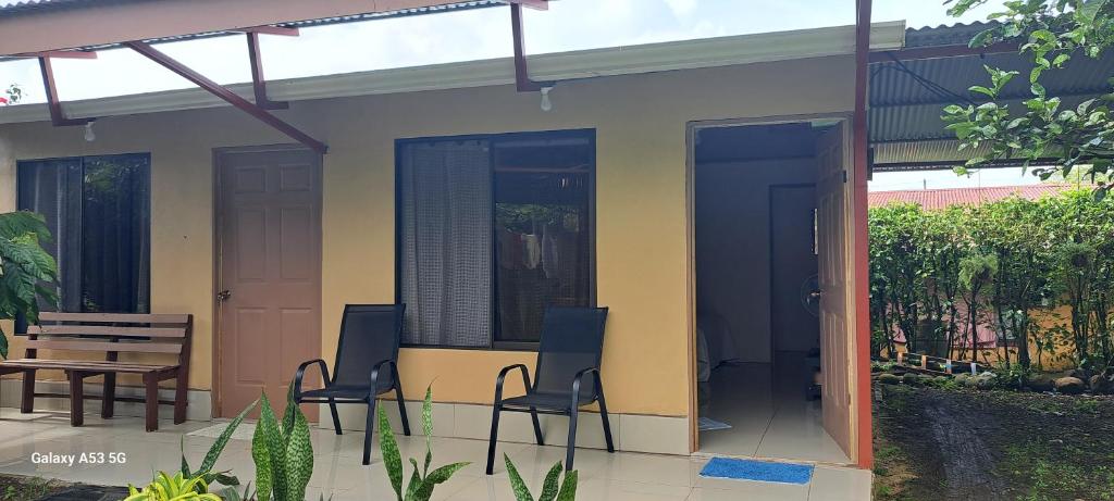 eine Terrasse mit Stühlen, einem Tisch und einem Haus in der Unterkunft Paradise Rio Celeste 2 in Bijagua