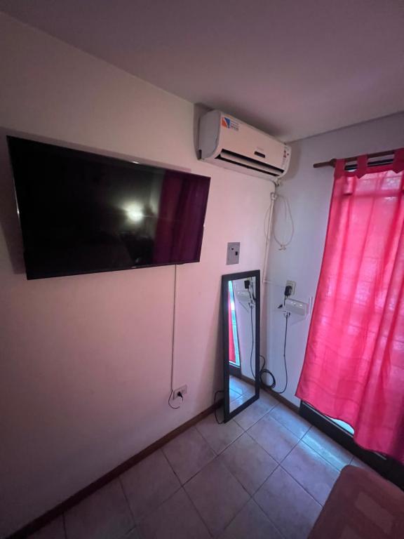 Habitación con TV de pantalla plana y ventana. en Departamento céntrico y tranquilo en Villa Marini